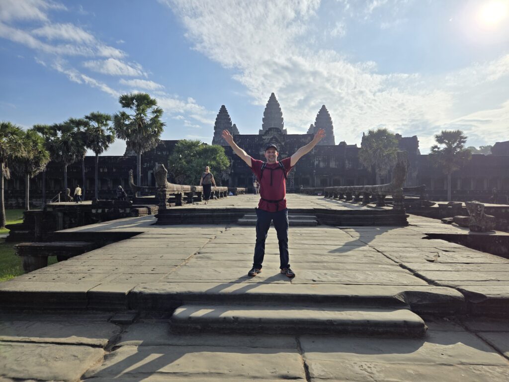 About A.J. andy in front of angkor wat hands raised december 2025
